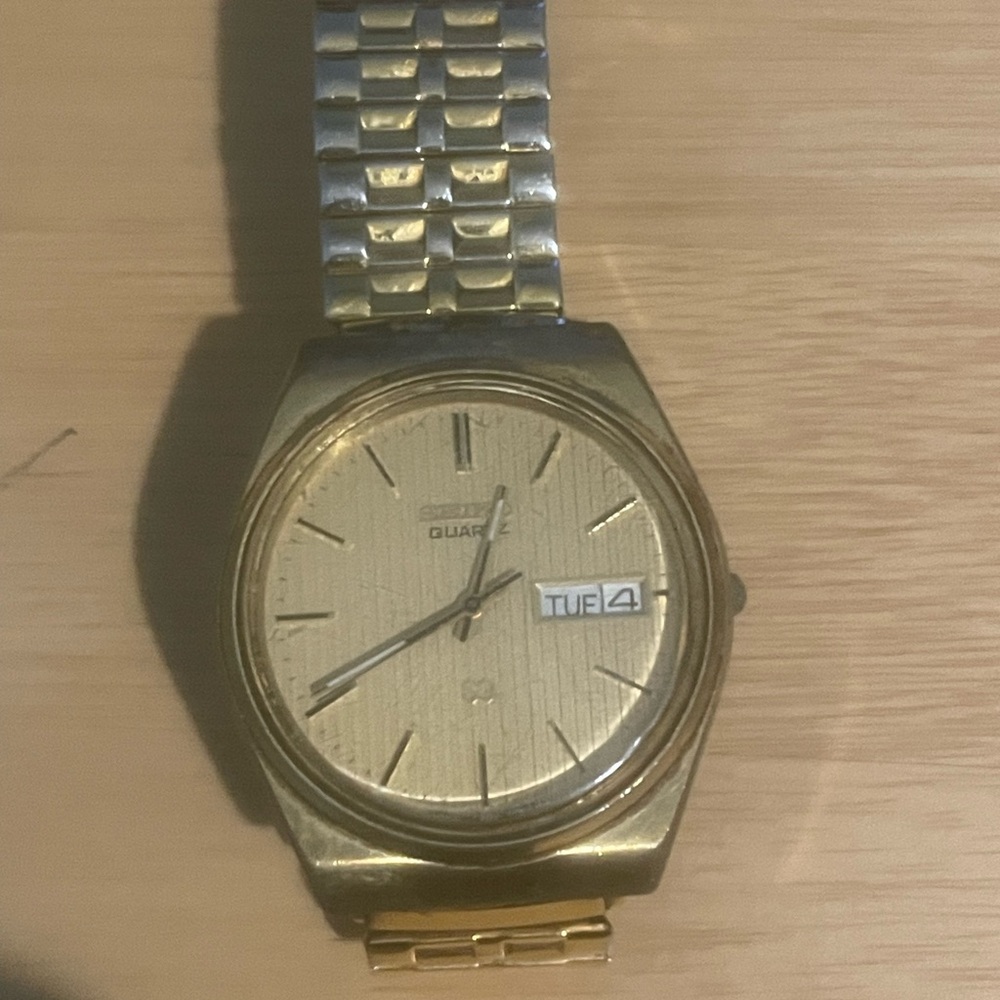Gold Quartz Watch with Silver Band. Needs batteries. Has scratches.